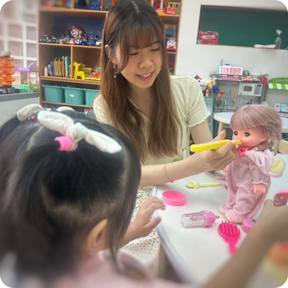 Teacher uses dolls in play therapy, fostering emotional expression and personalized learning.