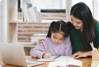 A woman and a child sit side by side,both immersed in their work, showcasing a moment of learning and connection.