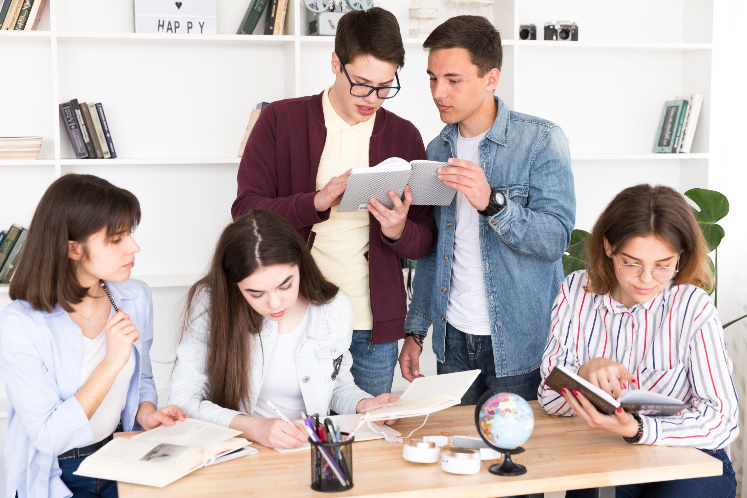 Group of students collaborating on a study project, working together around a table with books and notes, fostering teamwork and academic engagement.